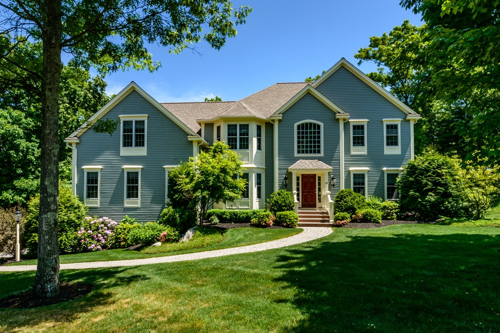 a front view of a house with a yard and trees