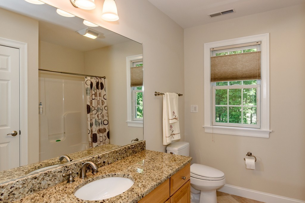 24 Overlook Drive Bedford, MA 01730 - Photo 25 of 30 a bathroom with a granite countertop toilet a sink and a mirror