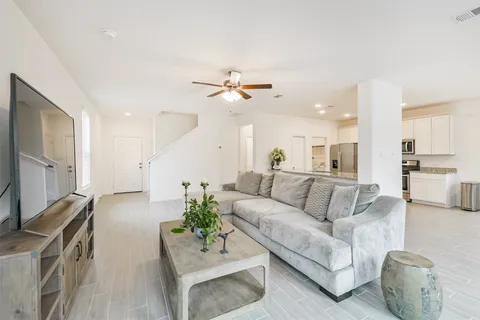a living room with furniture white walls and a flat screen tv