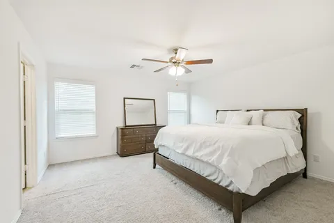 a spacious bedroom with a bed and a chandelier