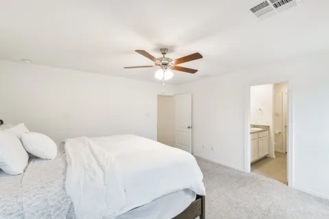 a bedroom with a bed and a ceiling fan