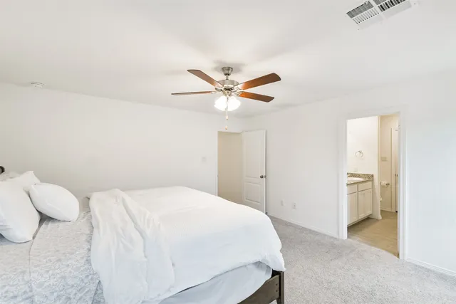 a bedroom with a bed and a ceiling fan
