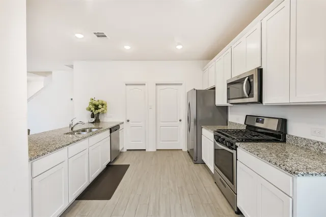 a kitchen with stainless steel appliances granite countertop a sink stove and refrigerator