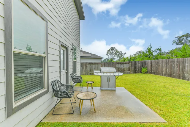 a view of a backyard with table and chairs and wooden fence
