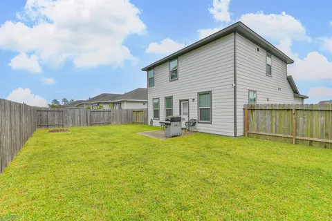 a view of a house with backyard and sitting area