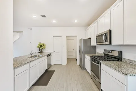 a kitchen with stainless steel appliances granite countertop a sink stove and refrigerator