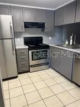 a kitchen with granite countertop a stove a refrigerator and a sink