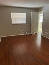 13250 Ridge Road, Unit 3B1 Largo, FL 33778 - Photo 6 of 15 an empty room with wooden floor and windows