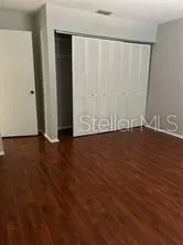 an empty room with wooden floor and closet