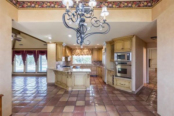 a open kitchen with a stove a refrigerator and dishwasher with a dining table
