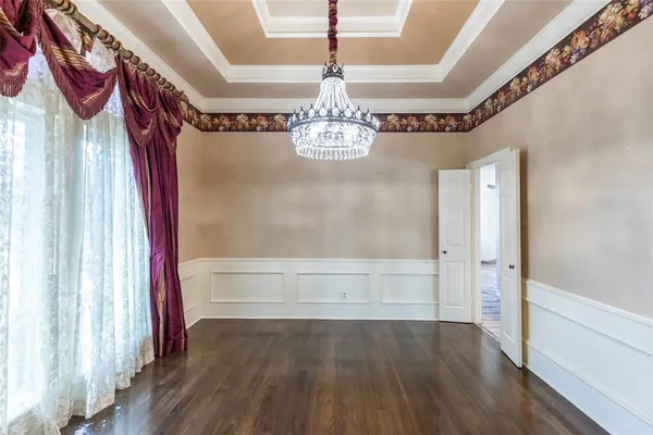 a view of a bedroom with wooden floor and windows