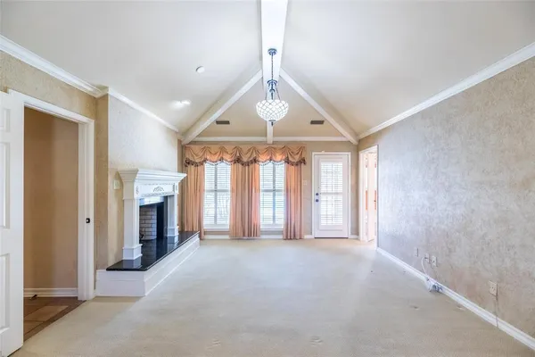 a view of an empty room with a fireplace and a window