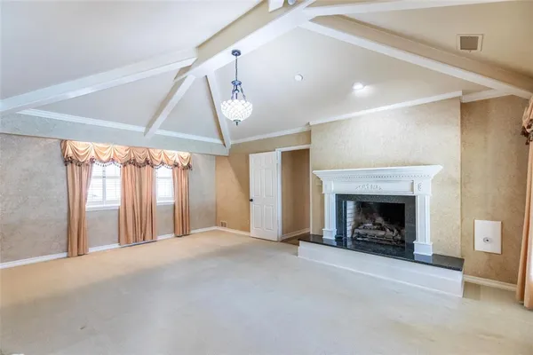 a view of an empty room with a fireplace and a window