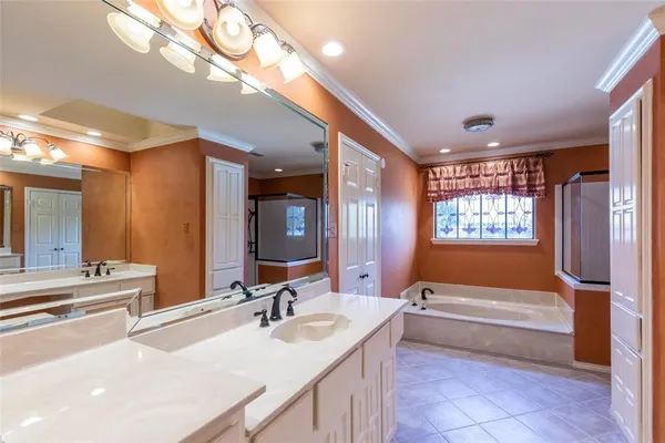 a bathroom with a tub a sink and a large mirror