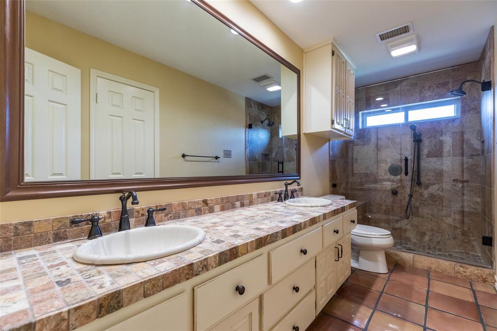 50 Riviera Circle Abilene, TX 79606 - Photo 39 of 40 a bathroom with a granite countertop sink a toilet a mirror and shower