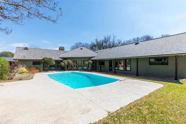 a view of a house with swimming pool and sitting area
