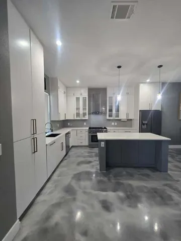 a large kitchen with a large counter top appliances and cabinets