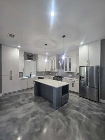 a large kitchen with kitchen island a sink stainless steel appliances and a cabinets