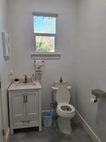 a bathroom with a toilet a sink and mirror