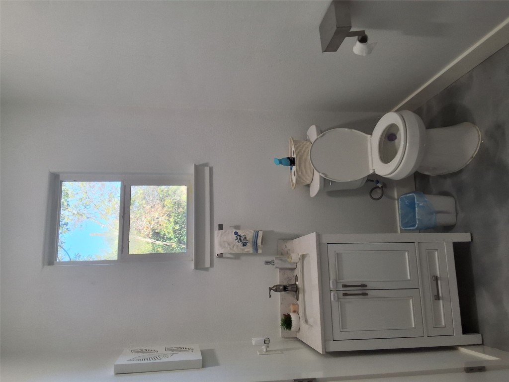 724 Ramsey Avenue Rockdale, TX 76567 - Photo 24 of 36 a bathroom with a toilet a sink and mirror