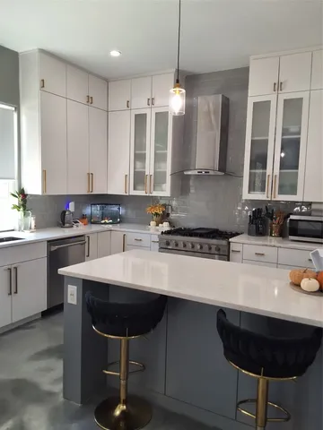 a kitchen with stainless steel appliances a sink a stove a refrigerator and cabinets
