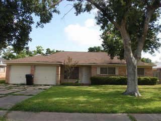 a view of a house with a yard and a large tree