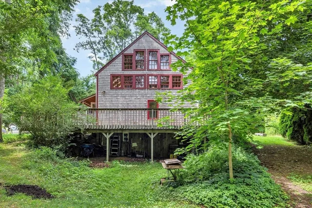 an aerial view of a house with a big yard and large trees
