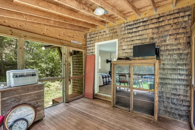 a living room with large windows and wooden floor