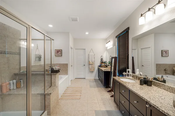 a spacious bathroom with a granite countertop sink mirror and shower