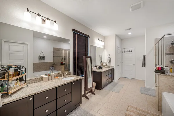 a spacious bathroom with a granite countertop sink mirror and shower