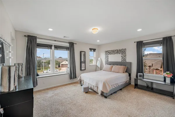 a spacious bedroom with a large bed and a large window