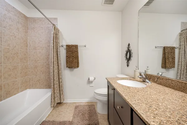 a bathroom with a granite countertop sink a toilet and bathtub