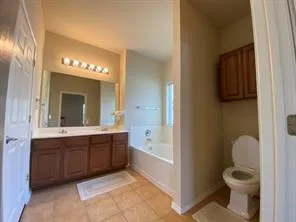 a spacious bathroom with a granite countertop sink mirror and toilet