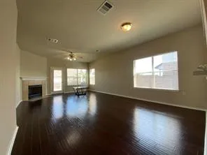 an empty room with wooden floor and fireplace