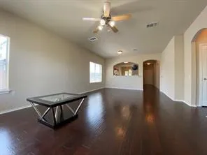 a view of an empty room with window and wooden floor