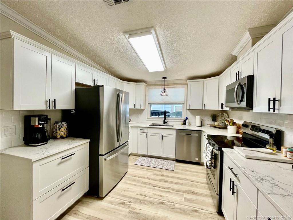 14513 Southwest Rake Drive Indiantown, FL 34956 - Photo 6 of 32 Complete Kitchen remodel. SS appliances, pull out shelves, soft close doors, new light fixtures & no touch sensor faucet