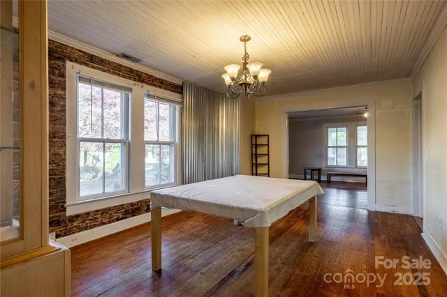 a view of a room with chandelier and wooden floor