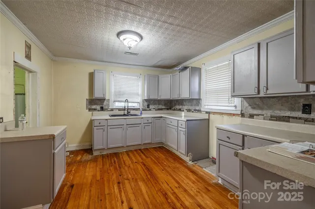 a kitchen with granite countertop a sink cabinets stainless steel appliances and window