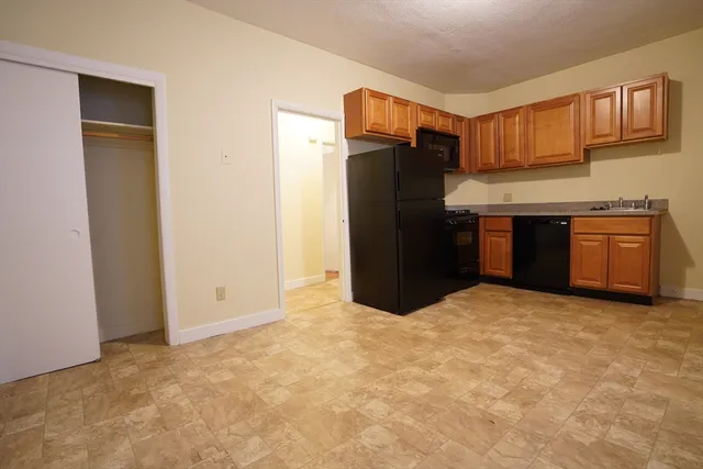 a kitchen with stainless steel appliances granite countertop a refrigerator and a stove top oven