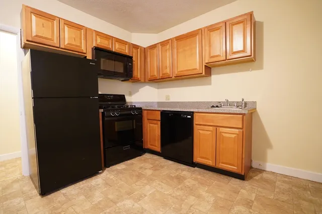a kitchen with a refrigerator stove and cabinets
