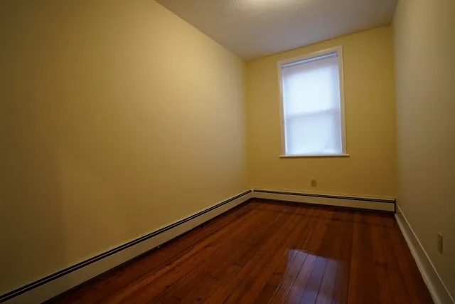 a view of a room with wooden floor and a window