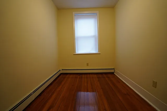 a view of a room with wooden floor and a window