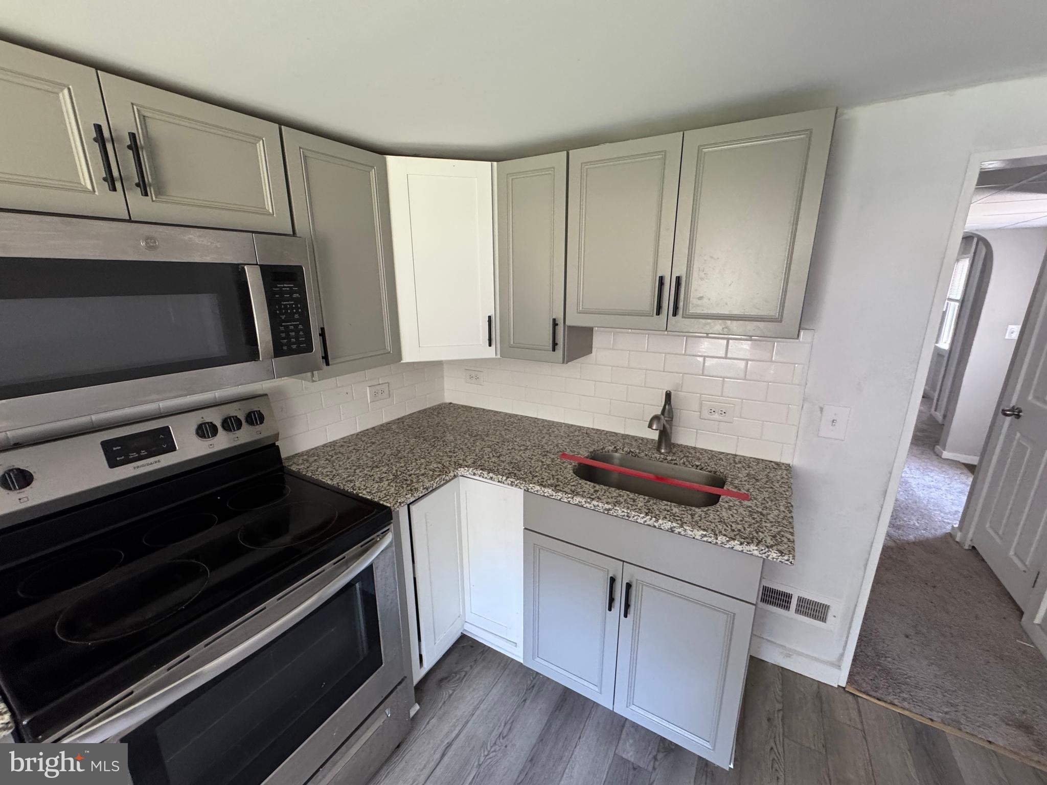 395 Tansboro Road Berlin, NJ 08009 - Photo 14 of 47 a kitchen with granite countertop a stove and a microwave