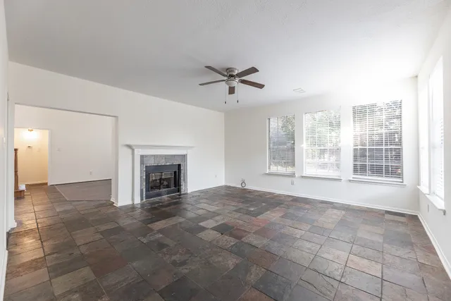 a view of an empty room with a fireplace and a window