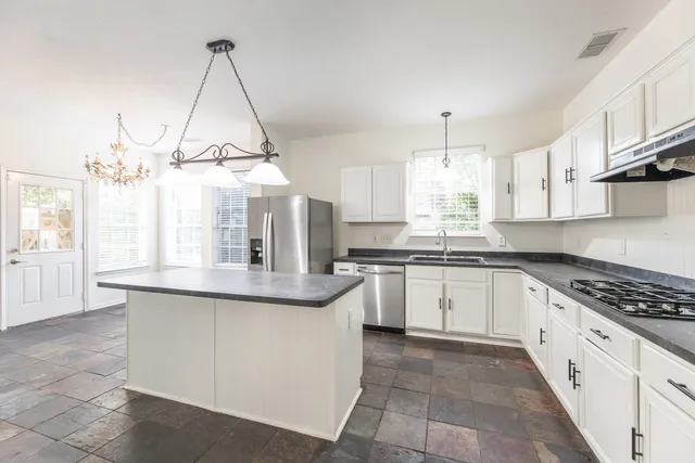 a kitchen with stainless steel appliances granite countertop a sink and cabinets