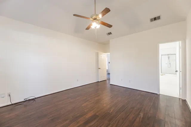 a view of an empty room with wooden floor
