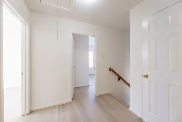 a view of a hallway with wooden floor and entryway