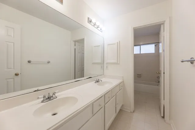 a bathroom with a double vanity sink a and mirror