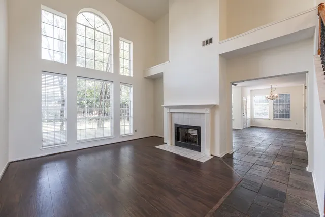 wooden floor fireplace and windows in an empty room