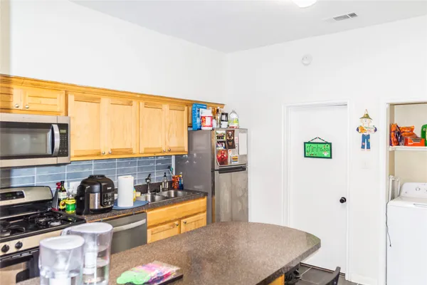 a kitchen with stainless steel appliances a refrigerator and a stove top oven